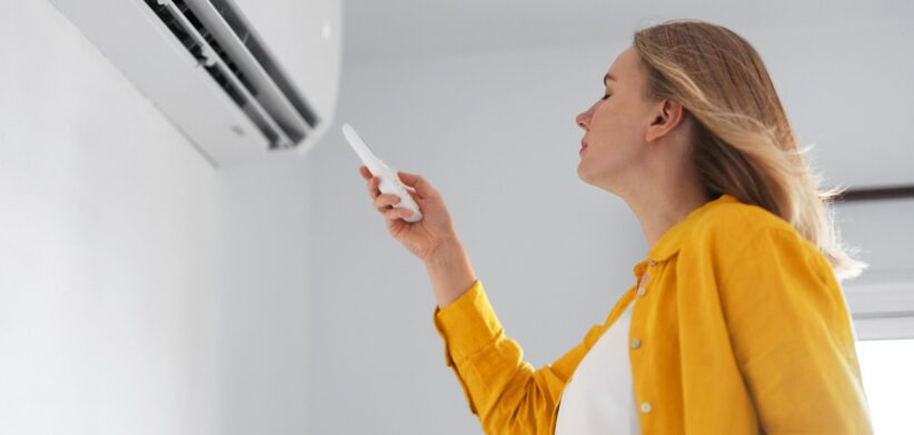 Woman in front of air conditioner. | Newsreel