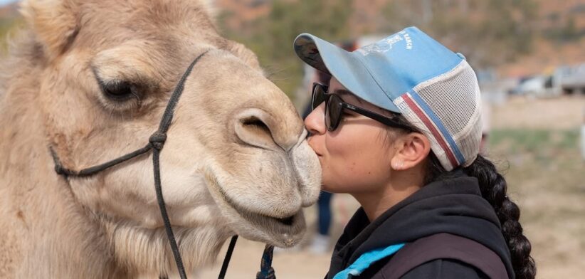 Person kissing a camel.