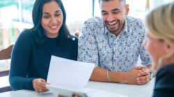 Couple looking at paperwork with business person. | Newsreel