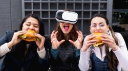 People eating burgers and wearing virtual reality glasses.