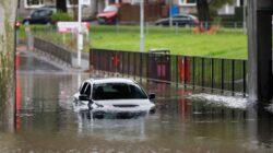 Car stuck in flooded road. | Newsreel