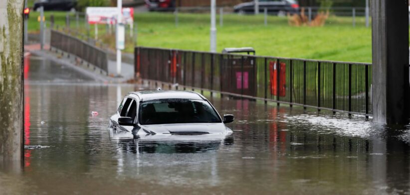 Car stuck in flooded road. | Newsreel