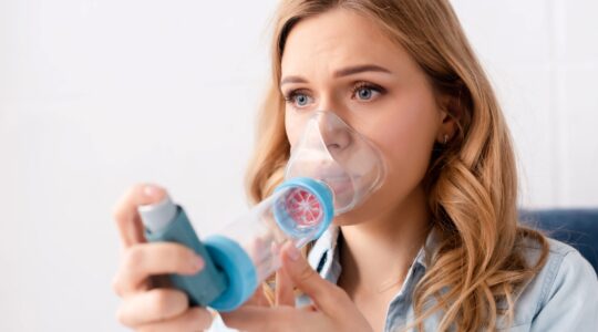 Woman using asthma puffer.