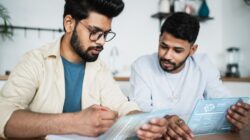 Two Indian men working on tablets