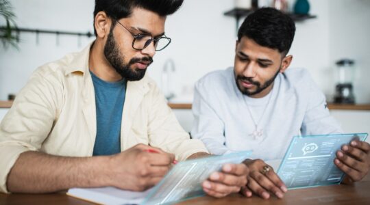 Two Indian men working on tablets