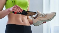 Woman inserting insole into shoe. | Newsreel