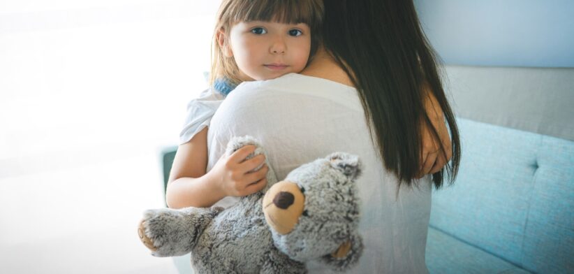 Child being hugged. | Newsreel
