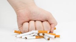 Fist crushing cigarettes. | Newsreel