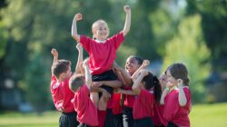 Girl being lifted by teammates. | Newsreel