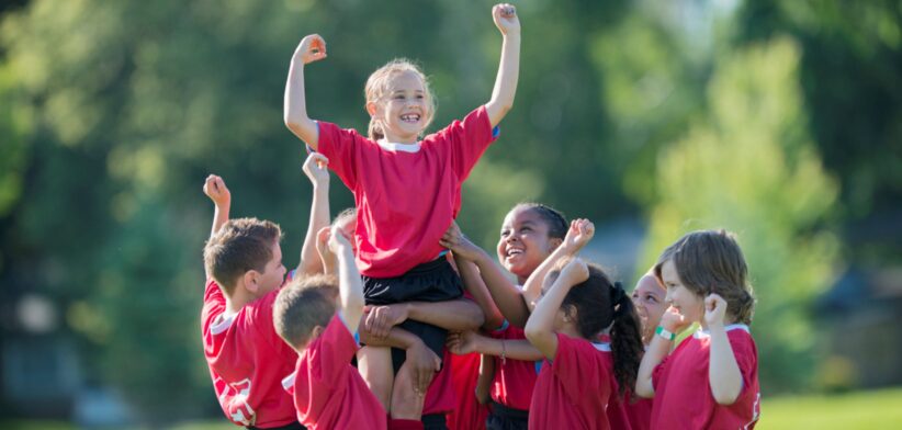 Girl being lifted by teammates. | Newsreel