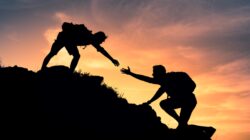 Person helping another climber. | Newsreel