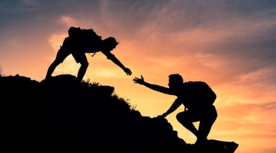 Person helping another climber. | Newsreel