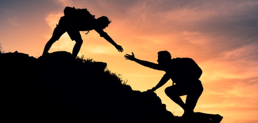 Person helping another climber. | Newsreel