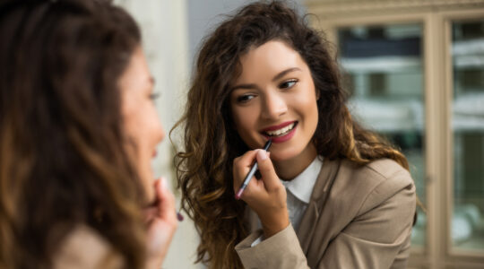 Woman applying lipstick