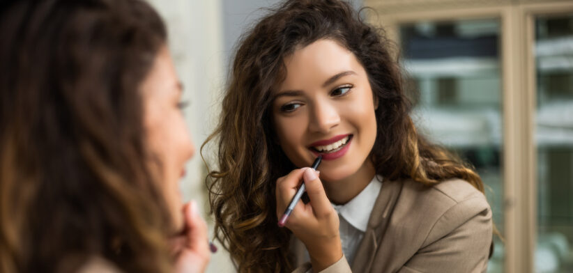 Woman applying lipstick