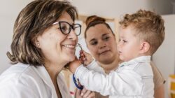 Doctor with young child and mum. | Newsreel