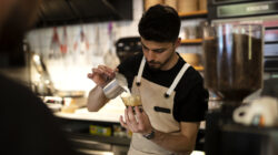 Male hand serving espresso latte