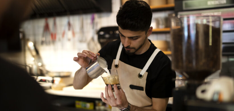 Male hand serving espresso latte