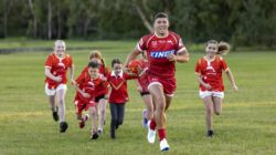Dolphins rugby league player and children in park. | Newsreel