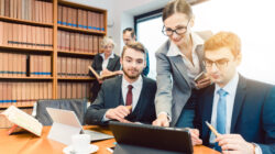 Lawyers in their law firm working on computer with books in background