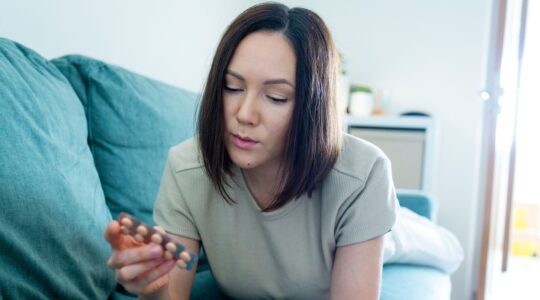 Woman looking at pills. | Newsreel