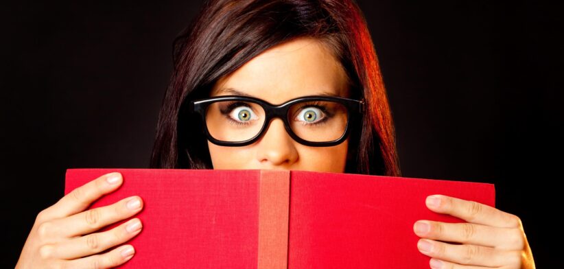Person peering over book. | Newsreel