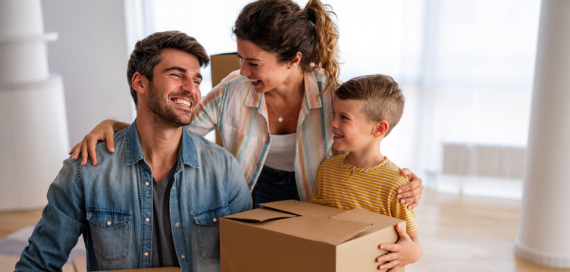 Moving, parents and child in new home bonding together, unpacking boxes for family time