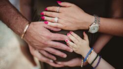 Multiple hands on pregnant belly.
