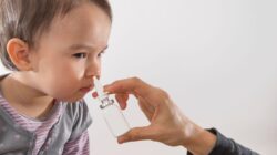 Child receiving a nasal spray. | Newsreel