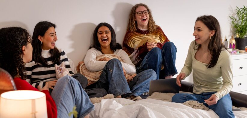 Young women siting on a bed. | Newsreel