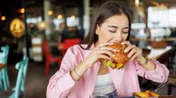 Woman eating a burger. | Newsreel