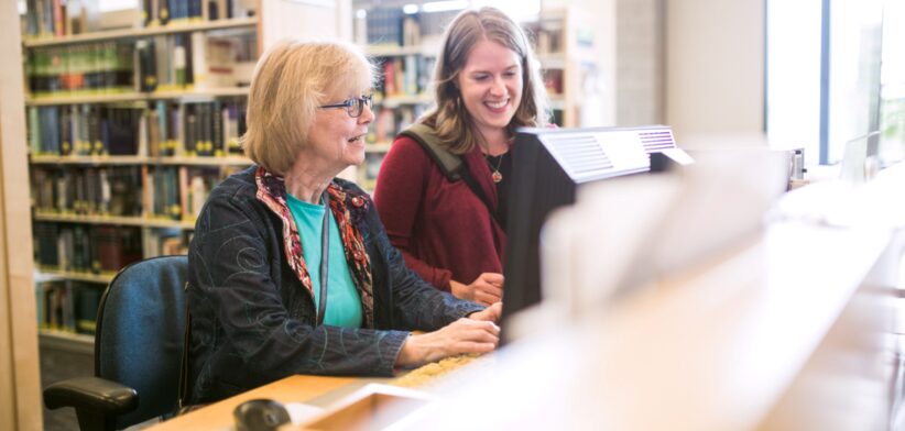 People using computer in library. | Newsreel