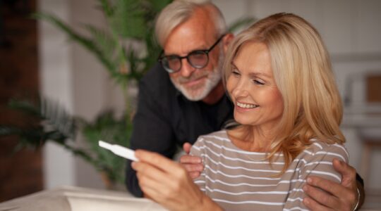 Mature couple looking at pregnancy test. | Newsreel