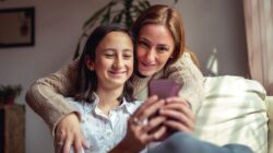 Mother and daughter looking at phone. | Newsreel