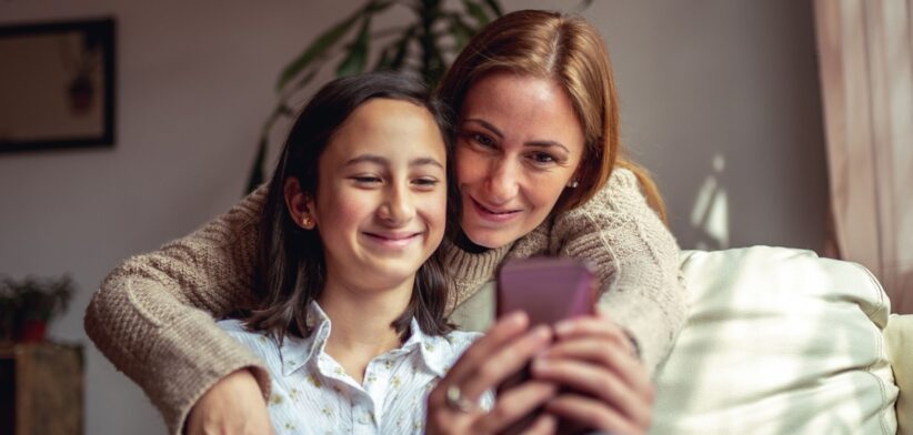 Mother and daughter looking at phone. | Newsreel