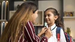 Loving mother getting her daughter ready for school at home