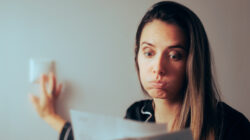 Woman Checking Electricity Bill Turning out the Lights at Home
