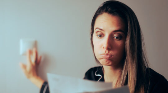 Woman Checking Electricity Bill Turning out the Lights at Home