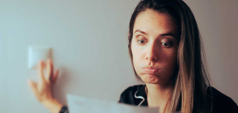 Woman Checking Electricity Bill Turning out the Lights at Home