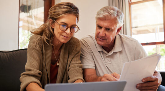 Retirement couple budget, finance and investment planning, loan and paper bills with laptop technology in home. Mature people money, cash savings or legal insurance document report on online bank