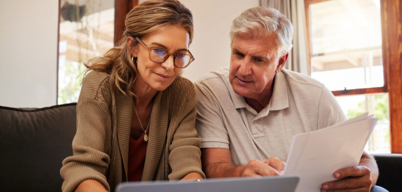 Retirement couple budget, finance and investment planning, loan and paper bills with laptop technology in home. Mature people money, cash savings or legal insurance document report on online bank