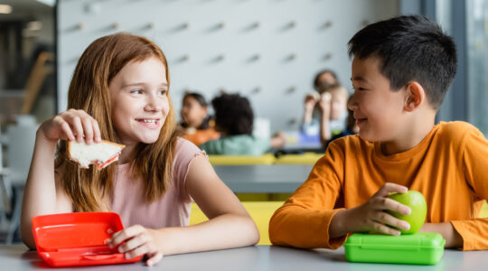 Joyful multicultural classroom with children enjoying lunch