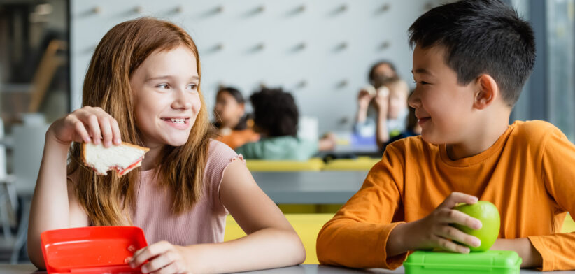Joyful multicultural classroom with children enjoying lunch
