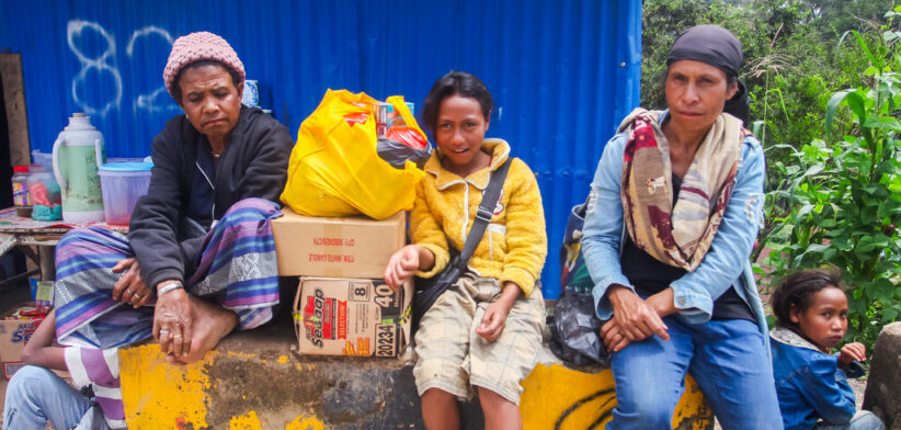 A family of residents of Ainaro Municipality, waiting for transportation after shopping at Maubisse Market, Ainaro, Timor Leste.