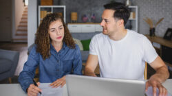 Young couple using laptop while planning their home budget