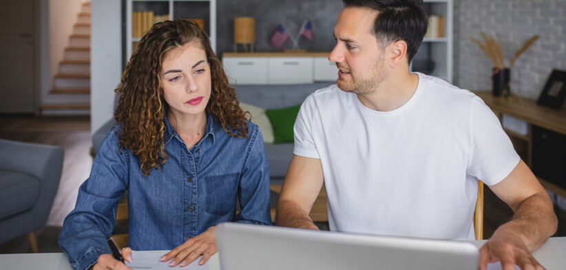 Young couple using laptop while planning their home budget