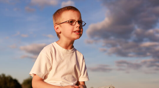 Boy sitting on hay bale