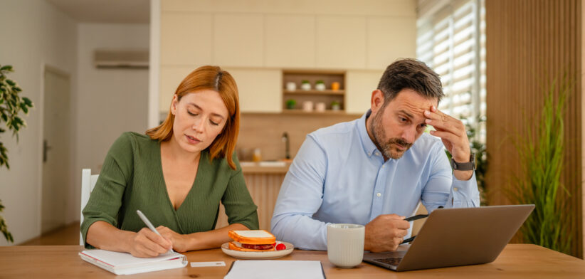 Couple managing home finances, stressing over bills and budget