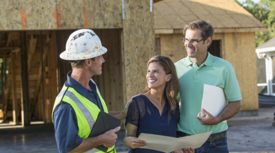 Builder and couple at new home under construction