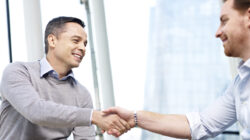 caucasian businesspeople shaking hands in office